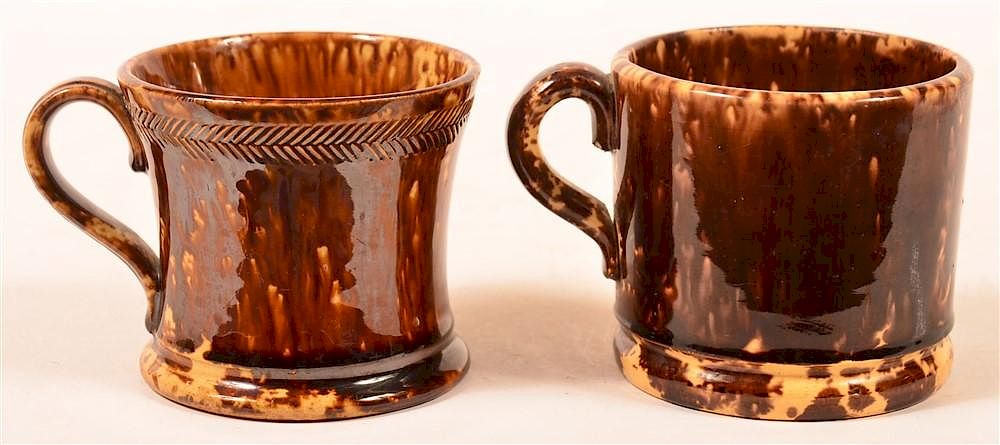 Appraisal: Two Rockingham Glazed Yellowware Mugs Two Rockingham Glazed Yellowware Mugs