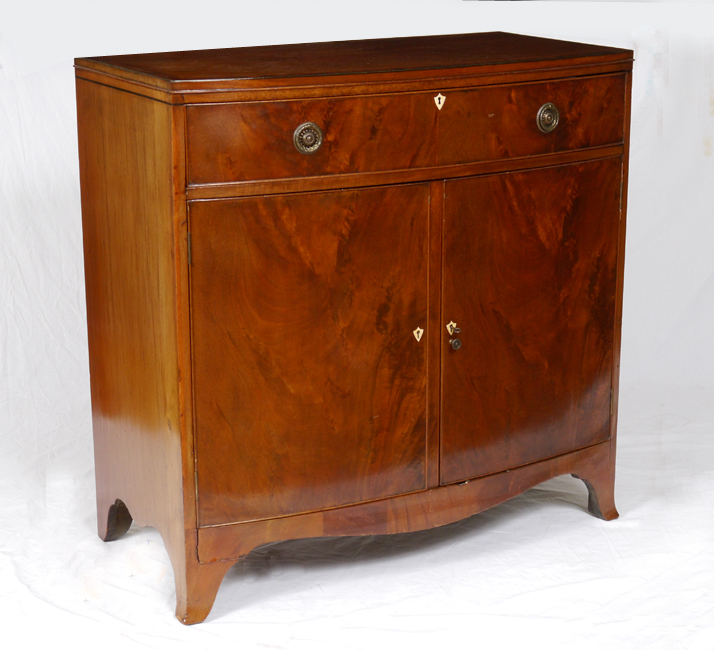 Appraisal: BOW FRONT MAHOGANY COMMODE Banded mahogany one drawer over doors