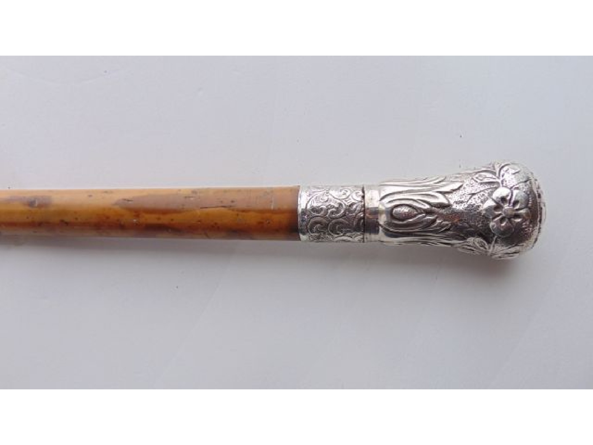 Appraisal: A Malacca walking cane terminating in a bulbous white metal