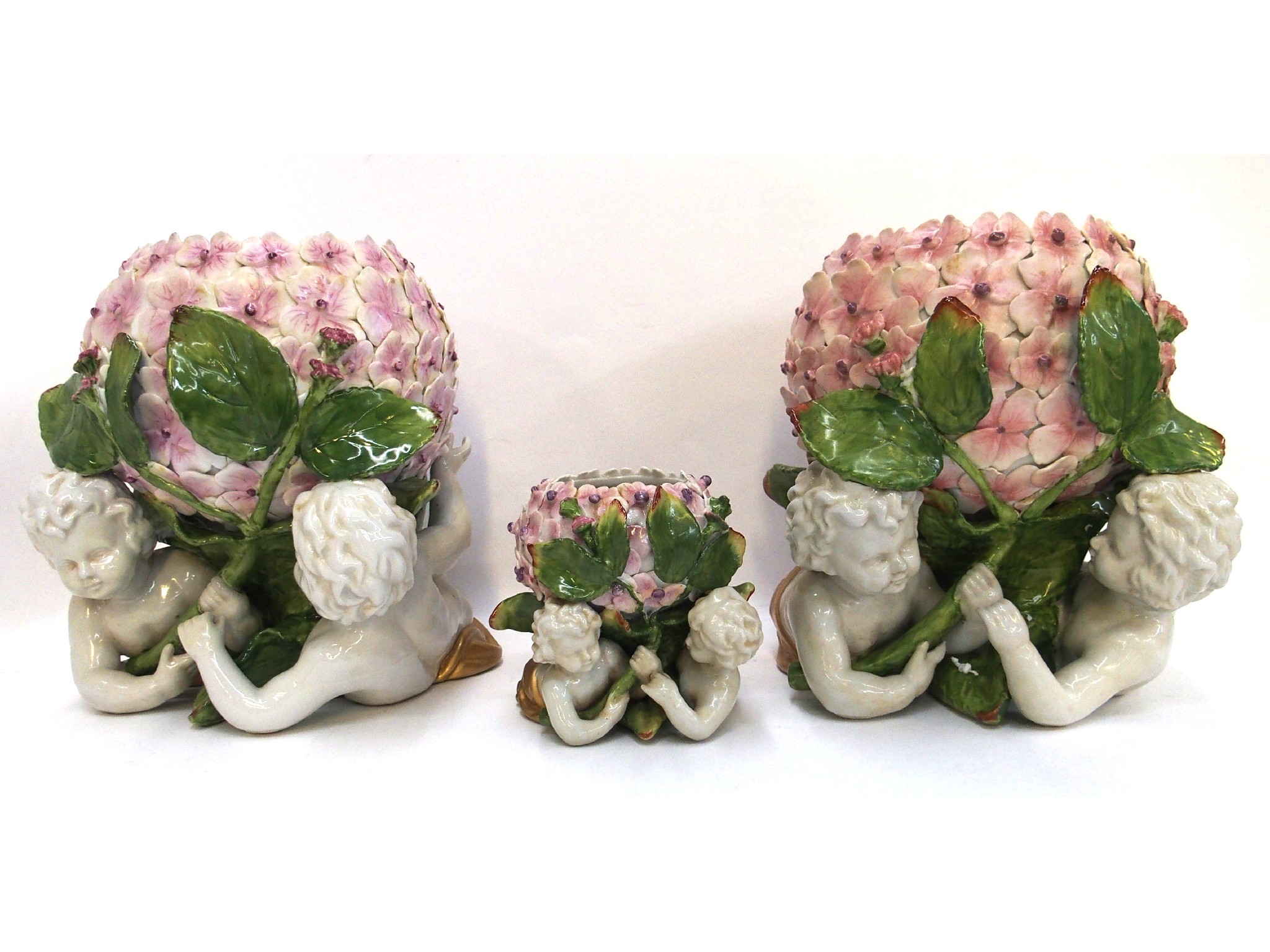 Appraisal: Pair of hydrangea flower decorated pots supported by cherubs and