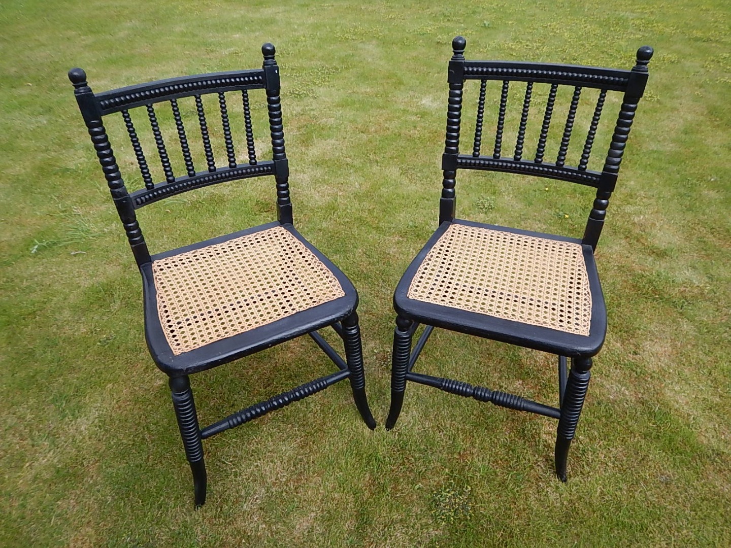 Appraisal: A pair of thC ebonised and cane seated single chairs