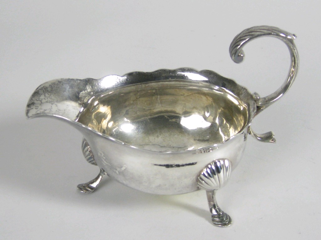 Appraisal: A George II Sauce Boat with shaped rim leafage scroll