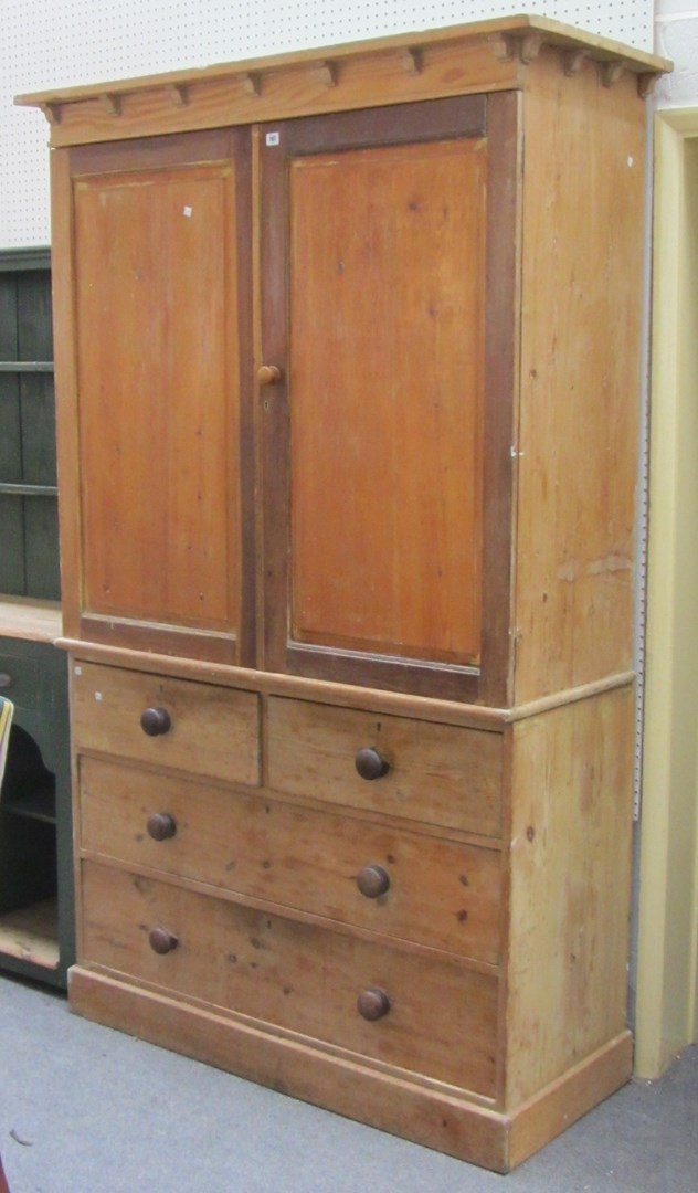 Appraisal: A Victorian pine housekeeper's cupboard the panel doors enclosing shelves