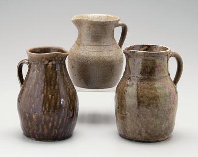 Appraisal: Three alkaline glaze pitchers one light olive glaze incised bands