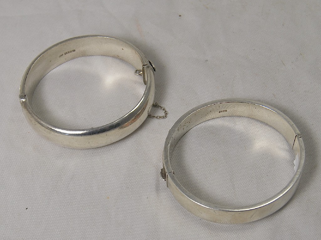 Appraisal: Two hollow silver hinged bangles both engraved with birds etc