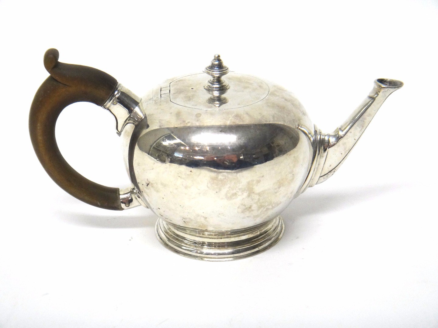 Appraisal: A silver bullet shaped teapot of spherical form on a