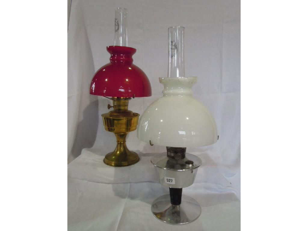 Appraisal: A brass oil lamp with red shade together with an