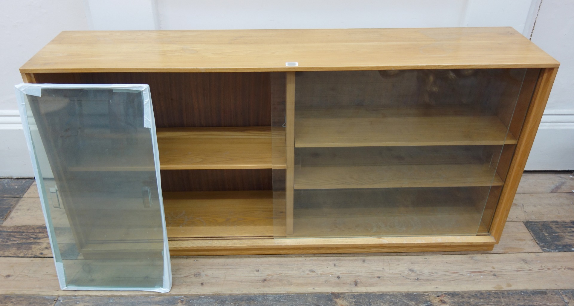 Appraisal: A Gordon Russell of Broadway dwarf bookcase enclosed by sliding