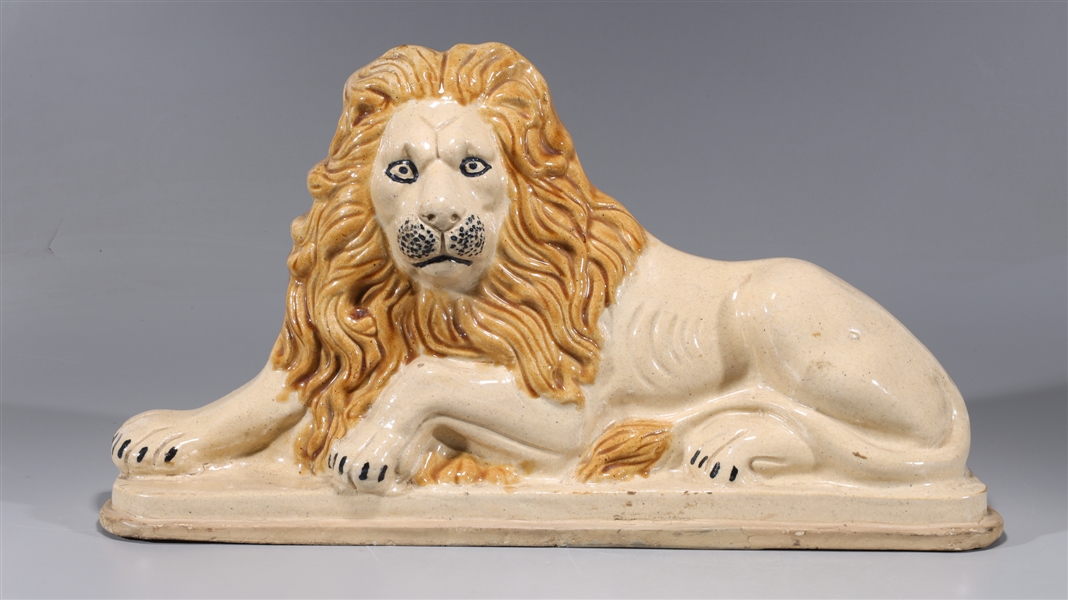 Appraisal: Large glazed porcelain high-relief lion statue with molded mane and