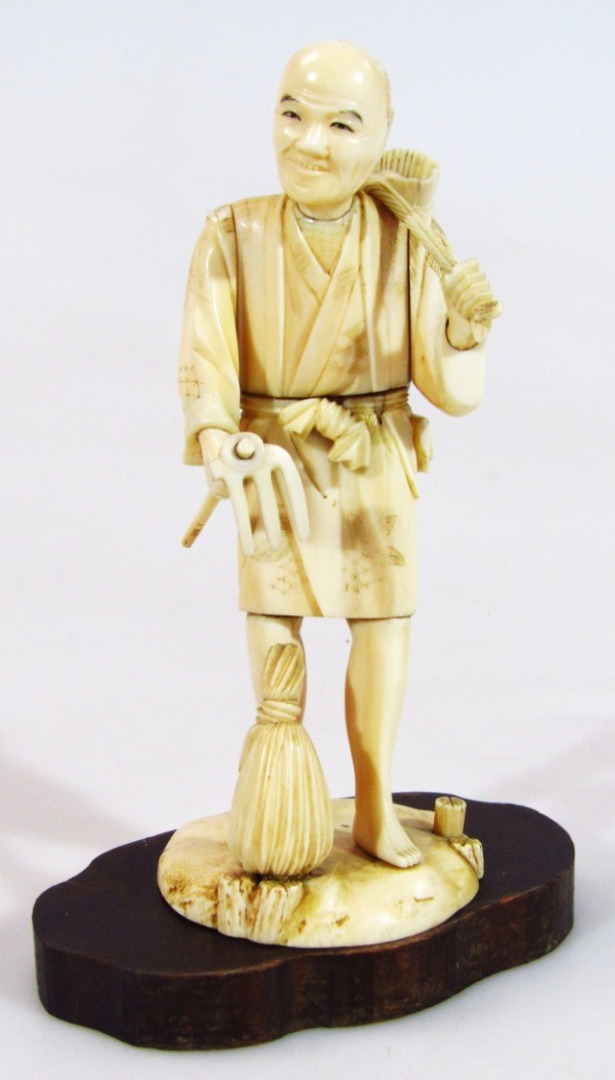 Appraisal: A thC ivory figure of a workhand in flowing robes