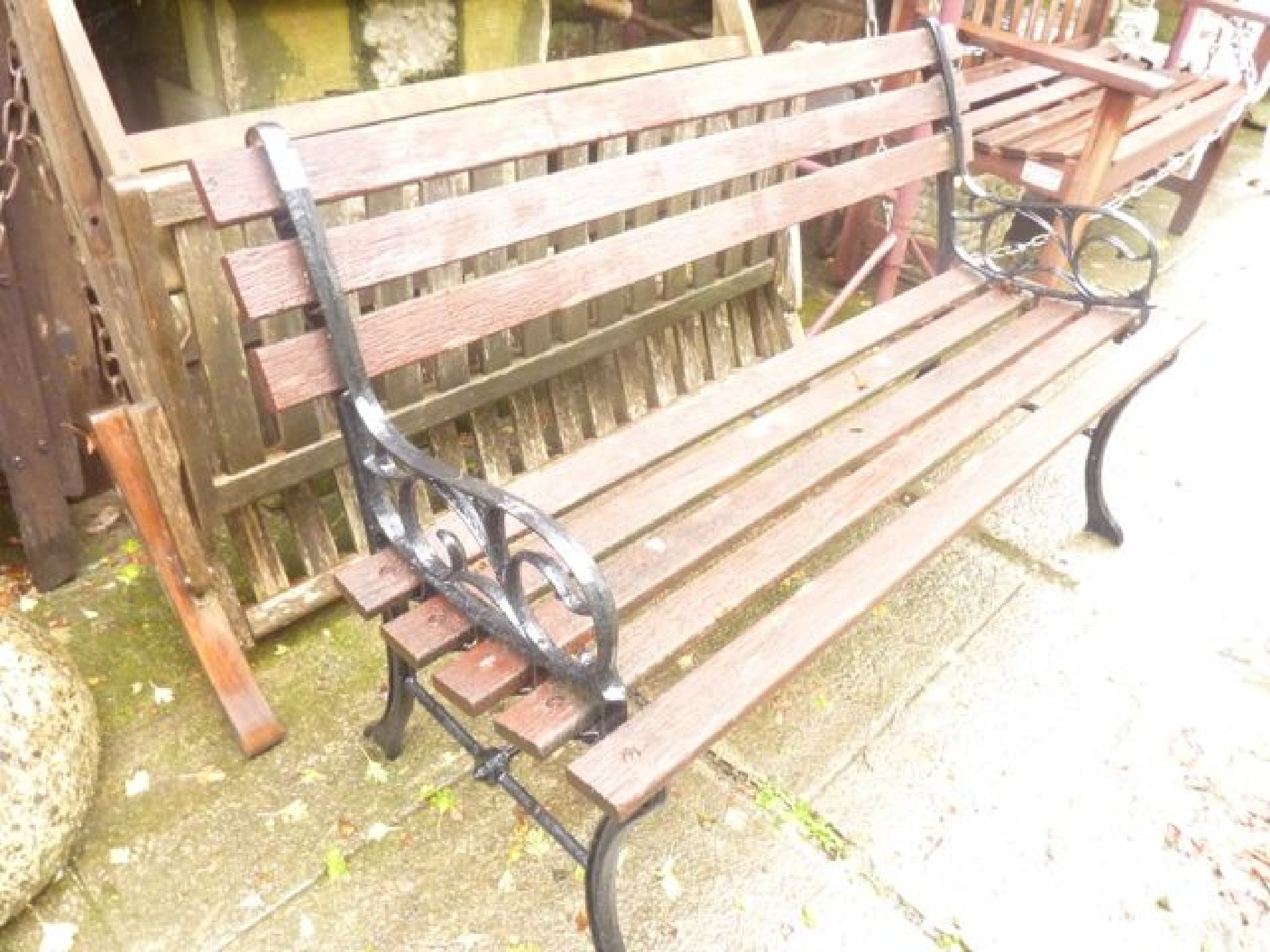 Appraisal: A contemporary two seat garden bench with stained timber slatted