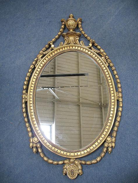 Appraisal: A NEO-CLASSICAL STYLE OVAL WALL MIRROR the plate within a