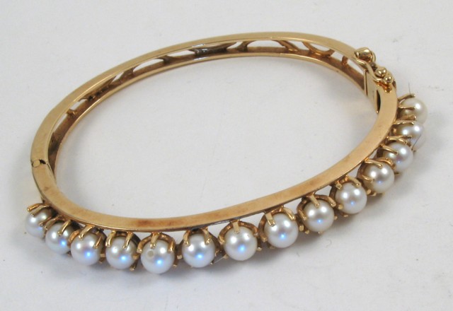 Appraisal: PEARL AND FOURTEEN KARAT GOLD BANGLE The hinged oval bangle