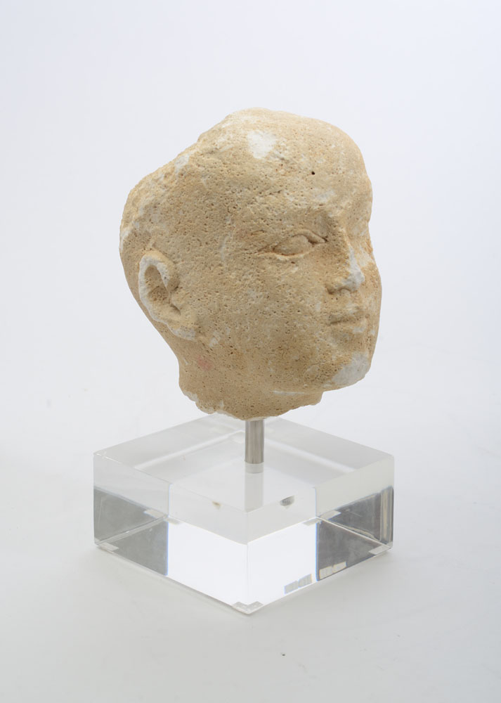 Appraisal: CARVED LIMESTONE HEAD OF A BOY Raised on a lucite