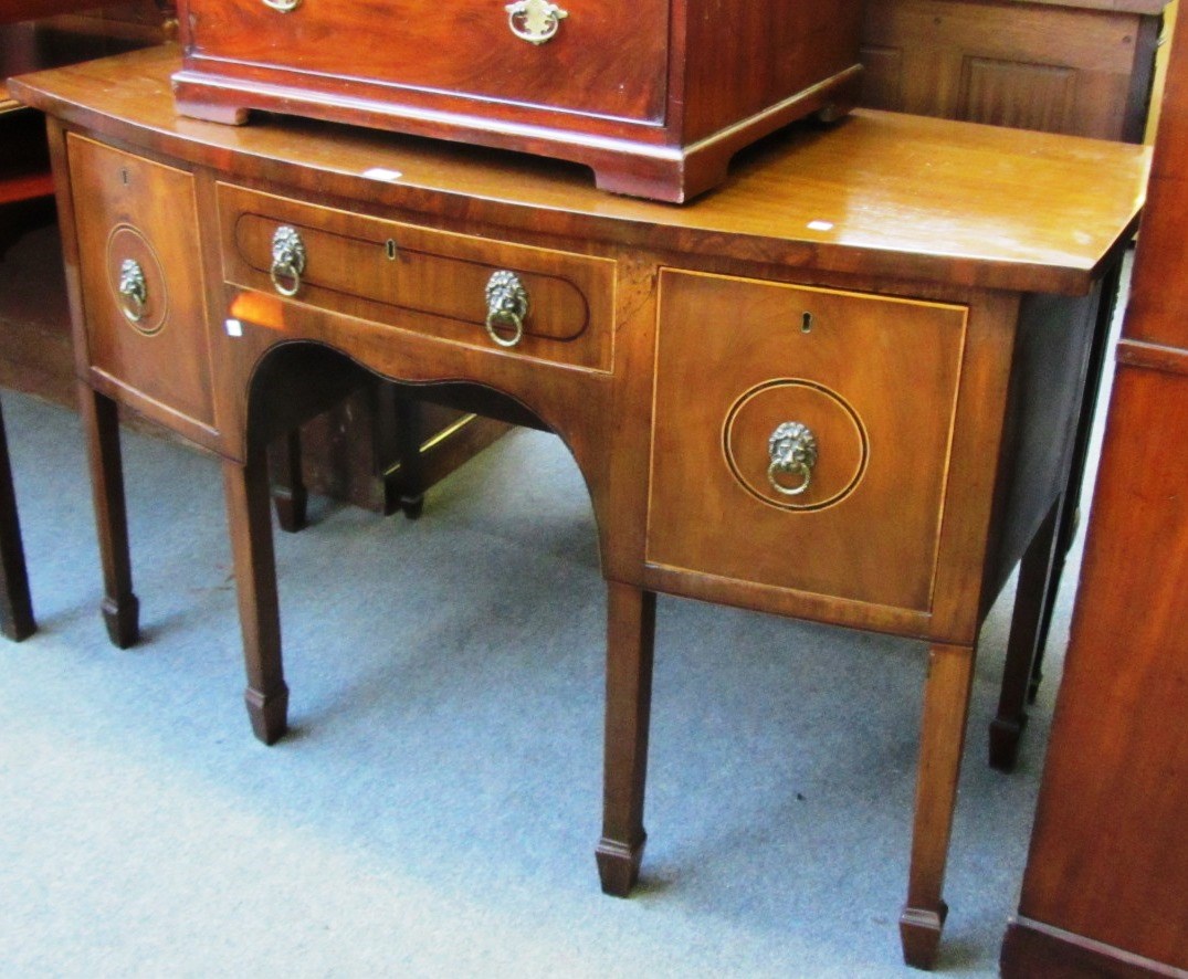 Appraisal: A George III mahogany bowfront sideboard with three frieze drawers