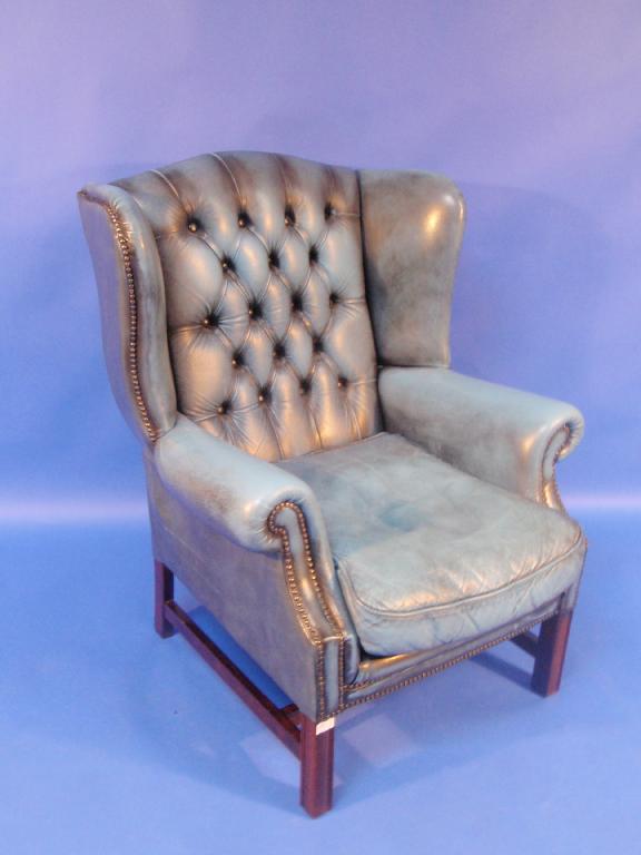 Appraisal: A blue leather effect finish button back wing armchair