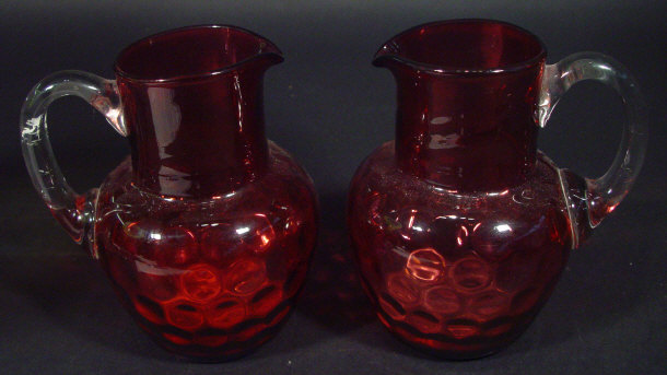 Appraisal: Two cranberry glass jugs with clear loop handles each cm