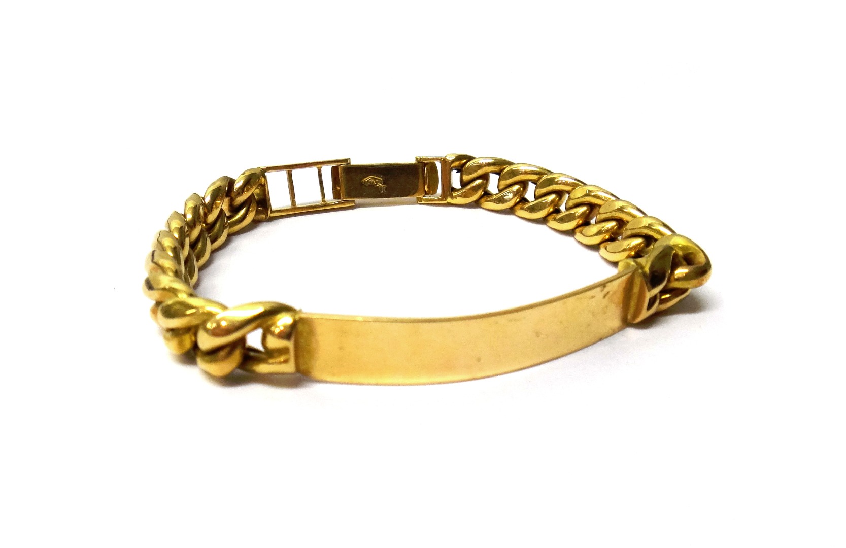 Appraisal: A gold curb link identity bracelet with a plain curved