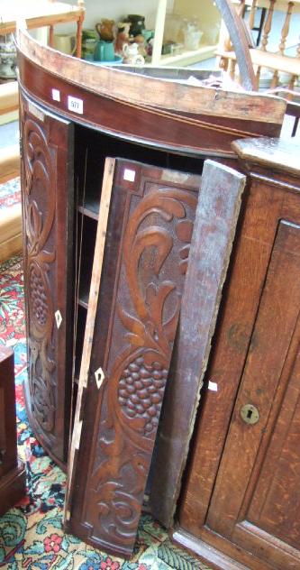 Appraisal: A th century mahogany and oak bowfront corner cupboard with