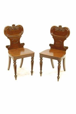 Appraisal: A pair of Victorian mahogany hall chairs with a leaf