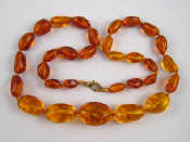 Appraisal: An amber bead necklace approx cm long largest bead approx