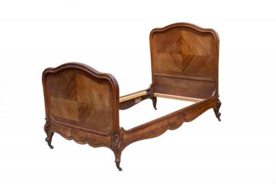 Appraisal: A French walnut bed with moulded arched head and foot