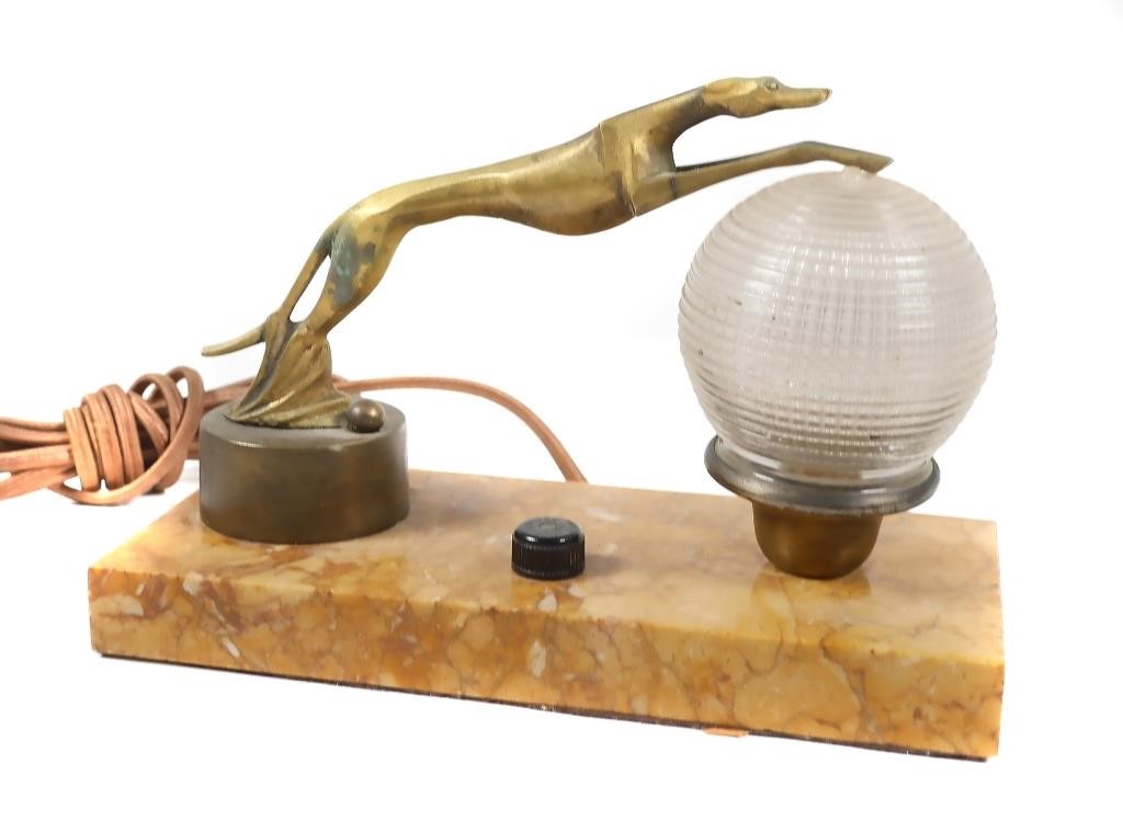 Appraisal: This Deco-era long electric mini-lamp features a greyhound leaping across