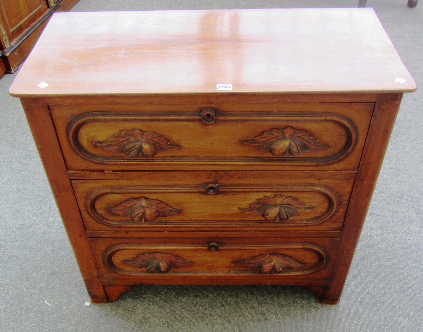 Appraisal: A small Victorian walnut three drawer chest with leaf carved