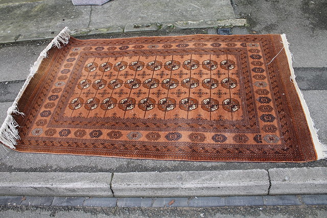 Appraisal: AN AFGHAN BOKHARA PALE RUST GROUND RUG with three rows