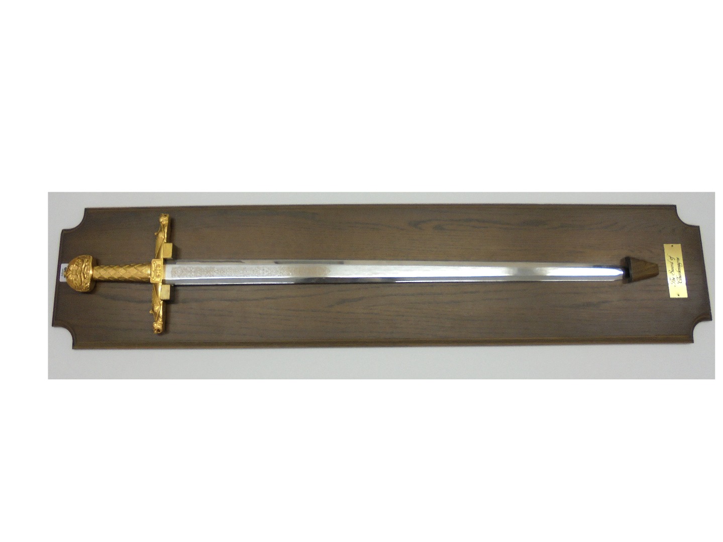 Appraisal: A reproduction sword of Charlemagne mounted on an oak backboard