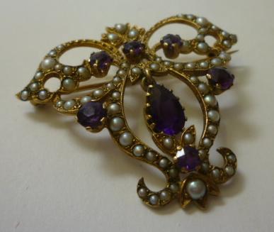 Appraisal: A VICTORIAN AMETHYST AND SEED PEARL BROOCH of pierced scroll