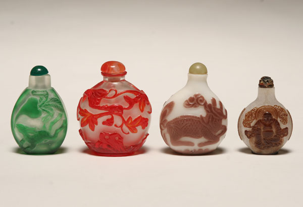 Appraisal: Four Chinese Peking glass snuff bottles all with carved decoration