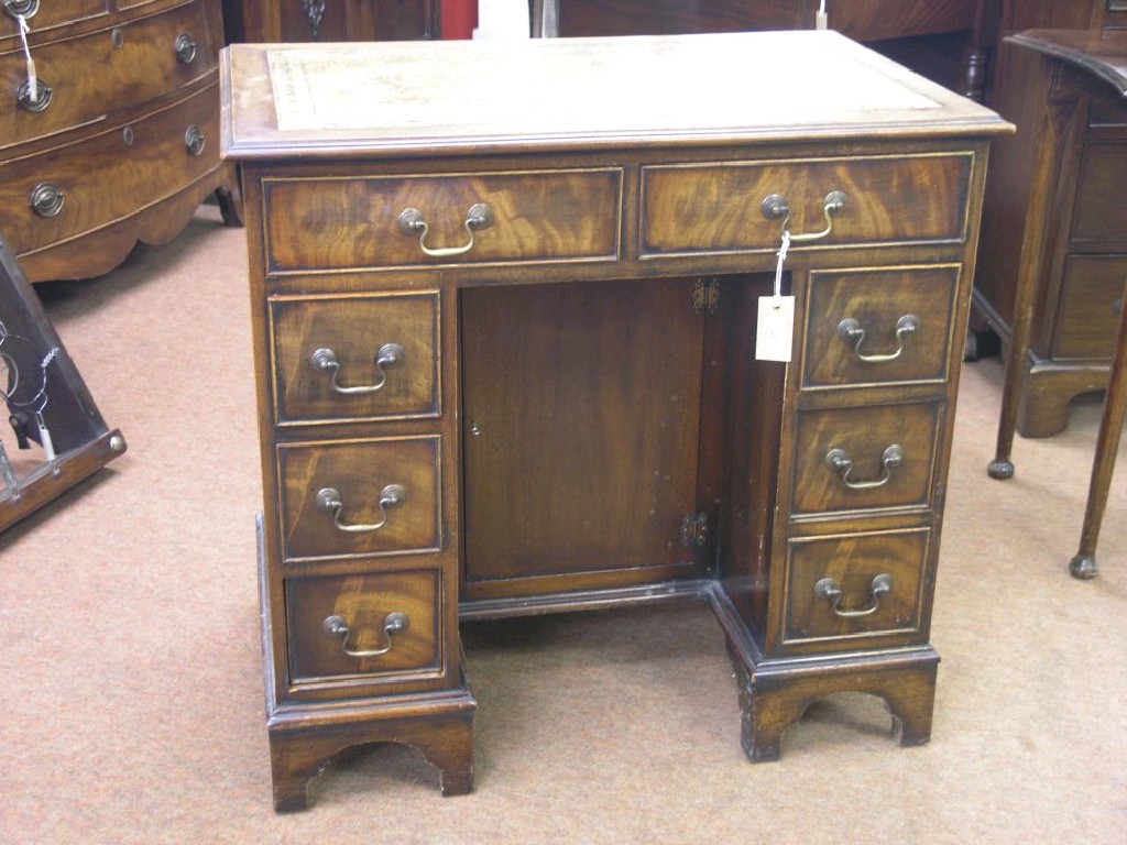 Appraisal: A Chippendale-style mahogany kneehole desk inset leather top above two