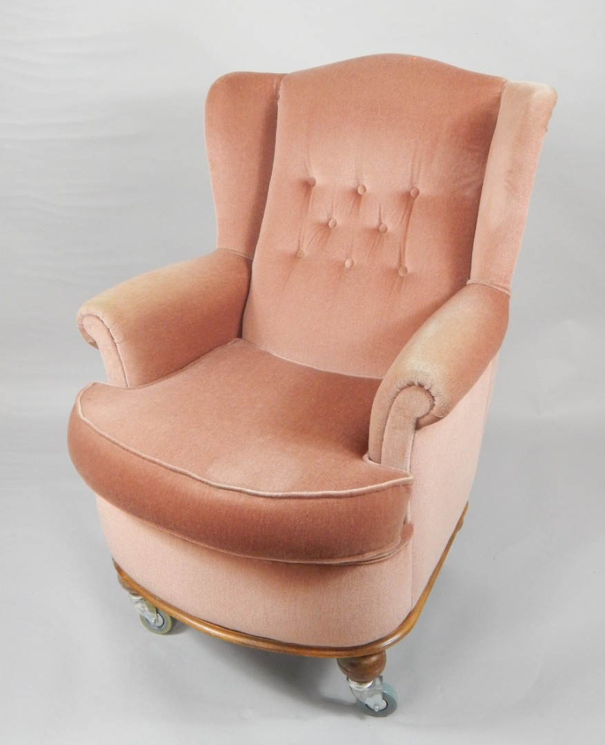 Appraisal: An oak wingback tub armchair upholstered in button back pink