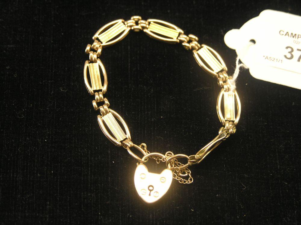 Appraisal: A ct gold link bracelet with heart shaped padlock pendant