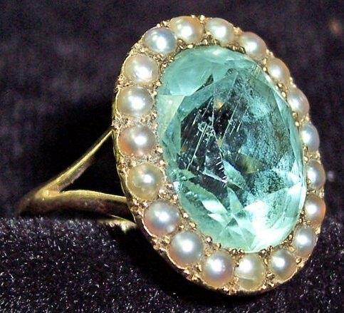 Appraisal: An oval aquamarine ring with border of half pearls