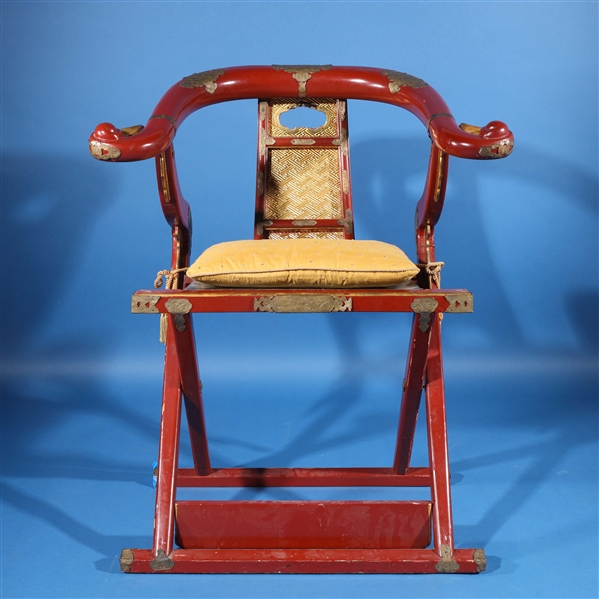 Appraisal: Chinese red lacquer folding chair with pillow and metal accents