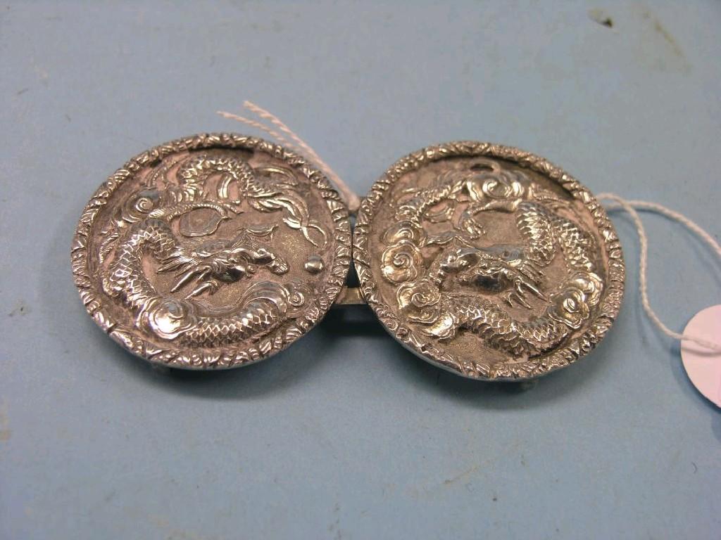 Appraisal: A Chinese silver belt buckle circular-shape cast with dragons