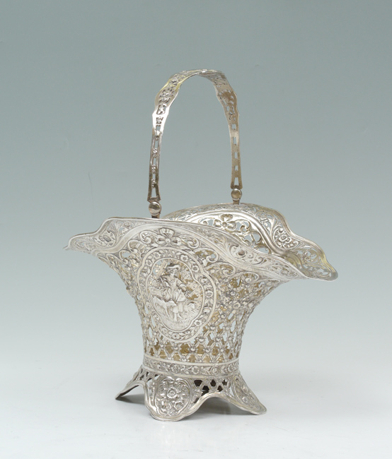 Appraisal: STERLING RETICULATED BASKET Articulated handle reticulated body with embossed medallion