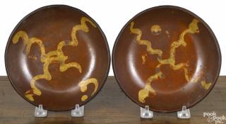 Appraisal: Two similar Pennsylvania redware shallow bowls th c with yellow