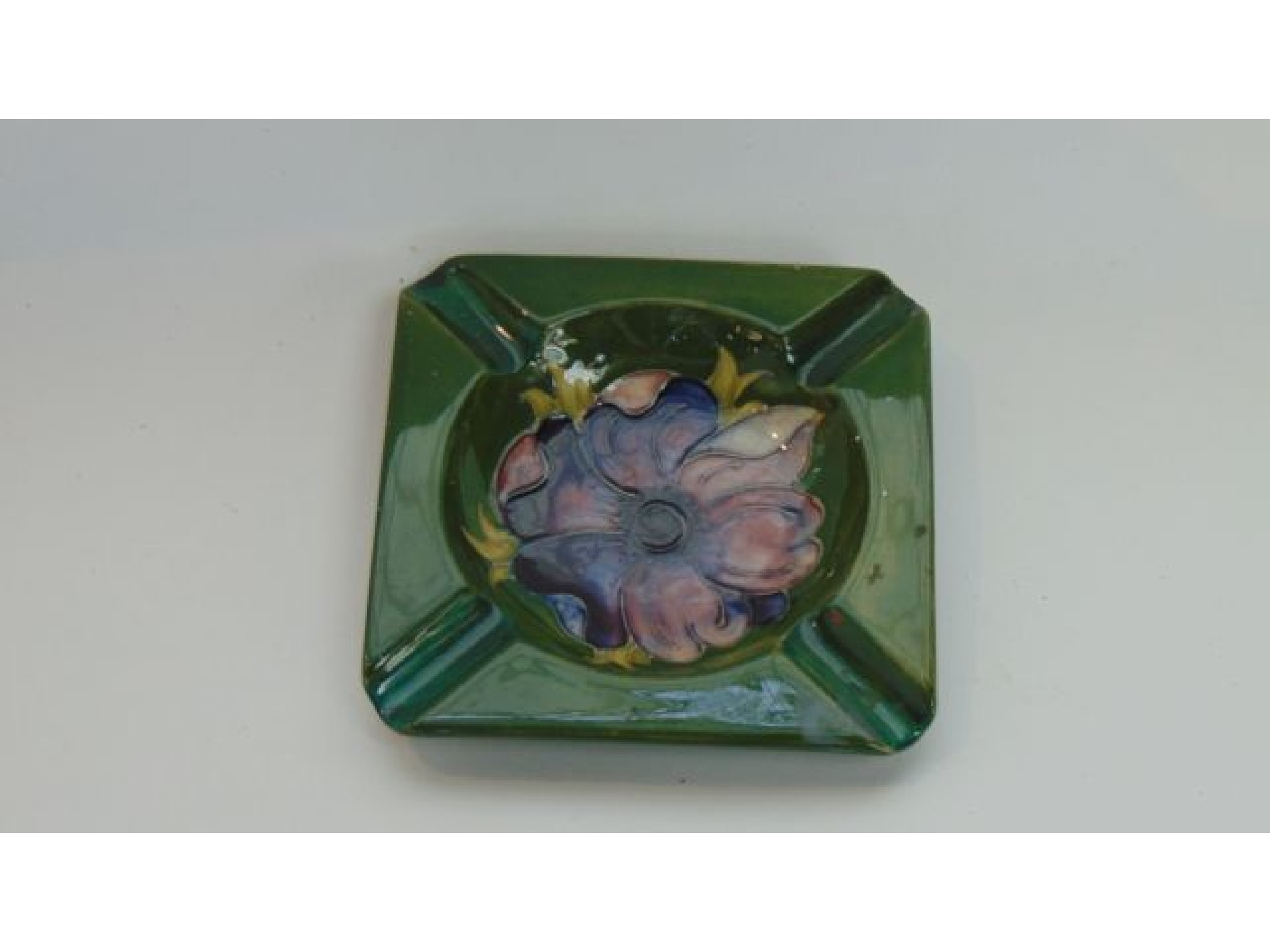 Appraisal: A Moorcroft green ground ashtray of square shaped form with