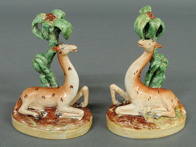 Appraisal: Rare pair of Staffordshire seated giraffes c with palm trees