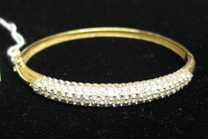 Appraisal: DIAMOND AND FOURTEEN KARAT GOLD BANGLE set with round facet-cut