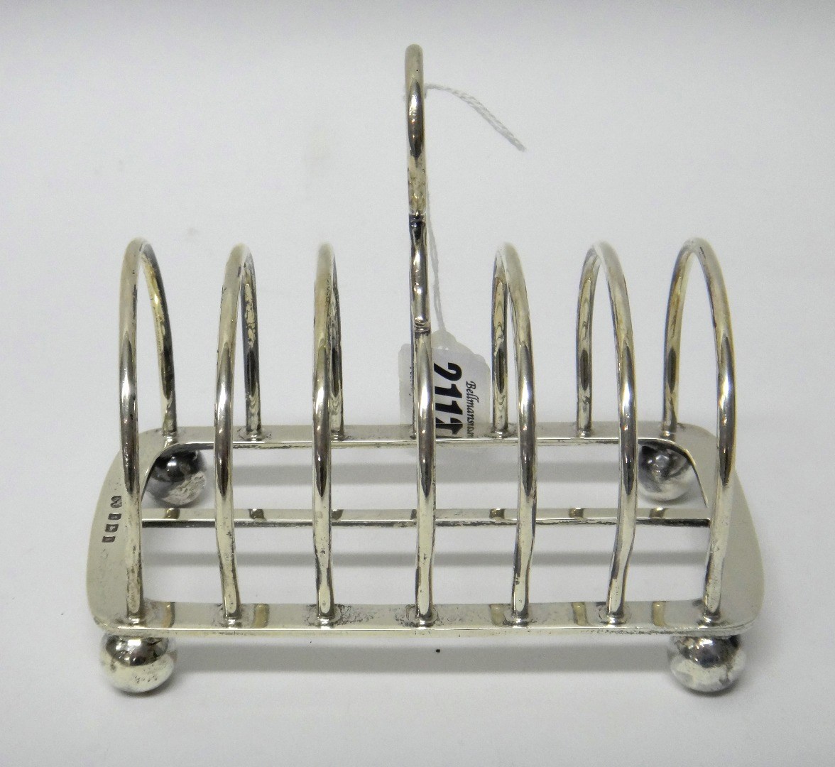 Appraisal: A silver seven bar toastrack with a loop shaped handle