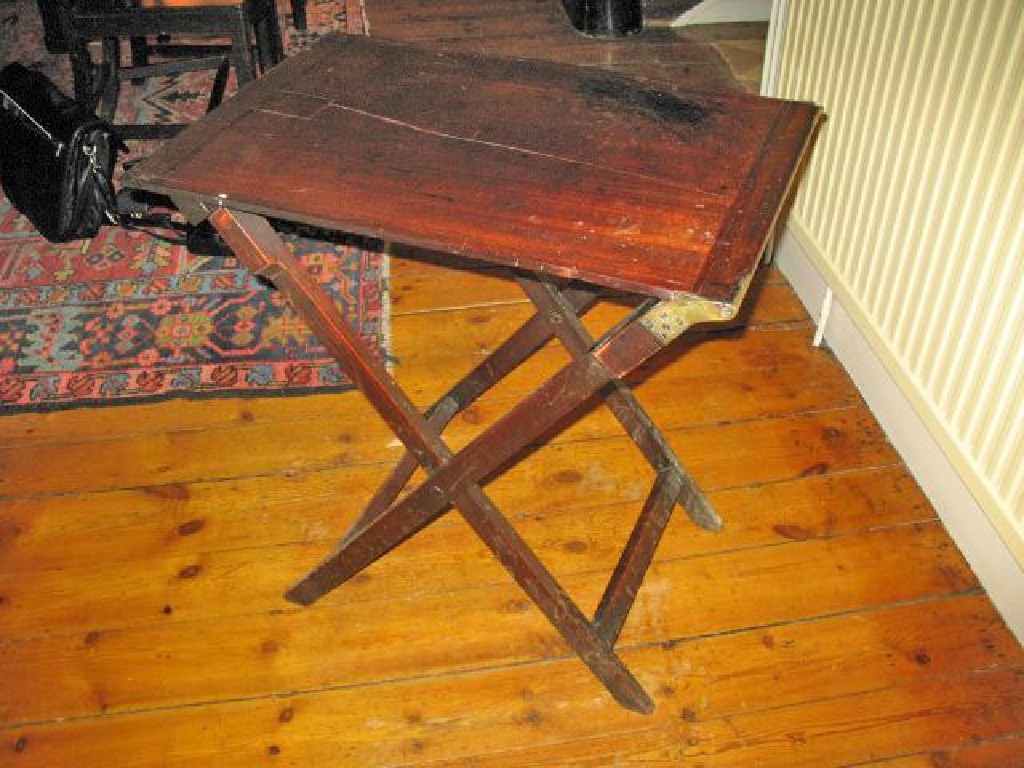 Appraisal: A MAHOGANY COACHING TABLE with brass mounts and a folding