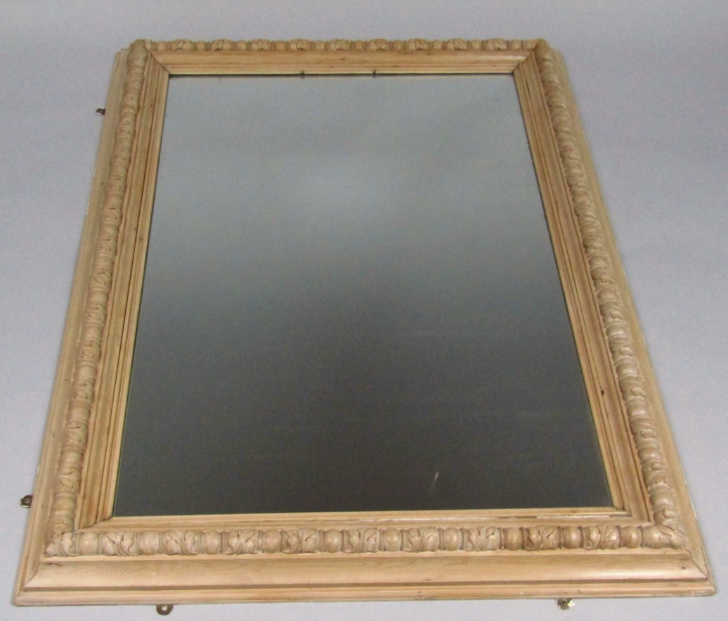 Appraisal: A heavily carved pine framed mirror of large proportion the