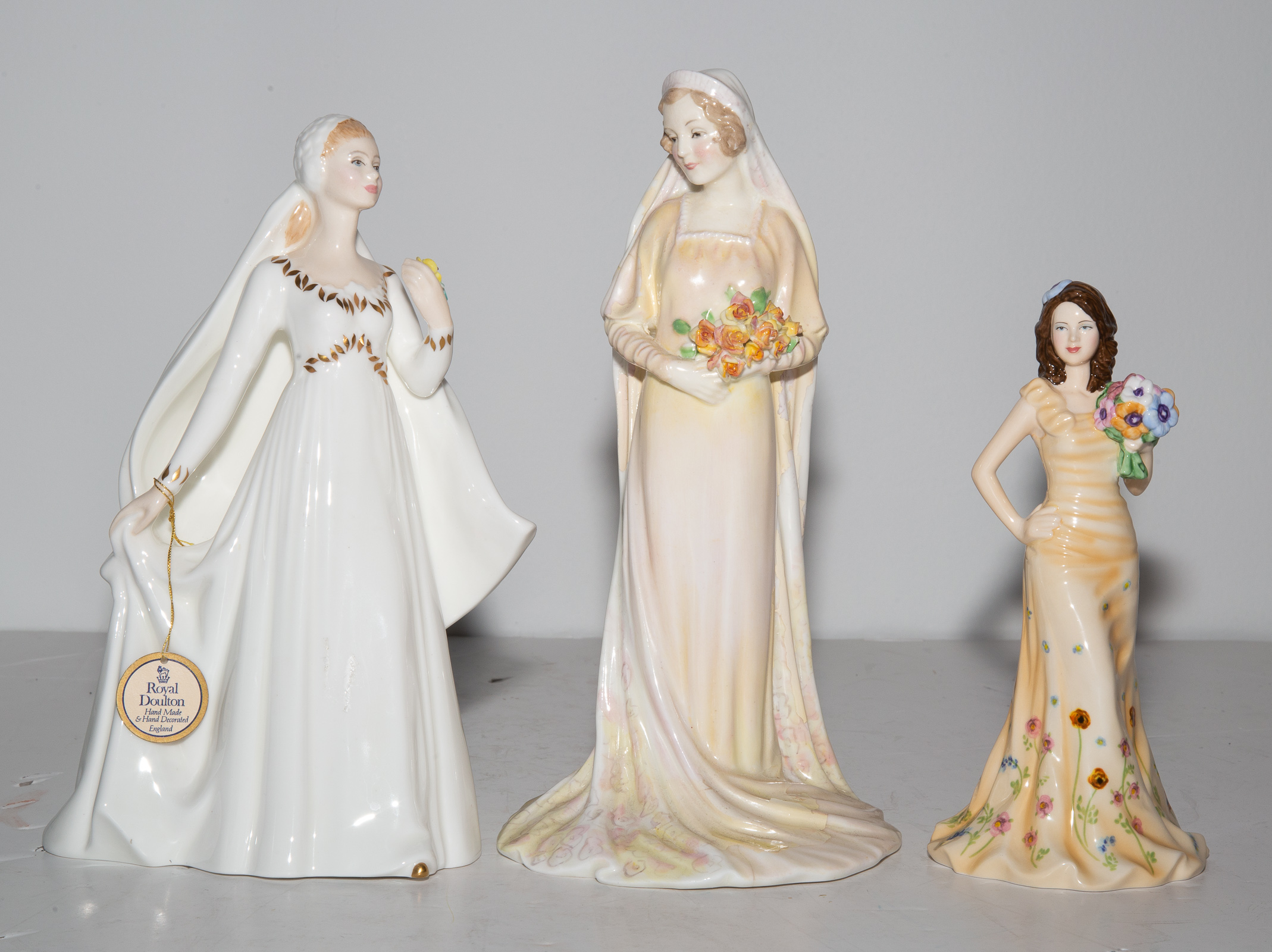 Appraisal: THREE ROYAL DOULTON FIGURES Including two Brides and Georgia