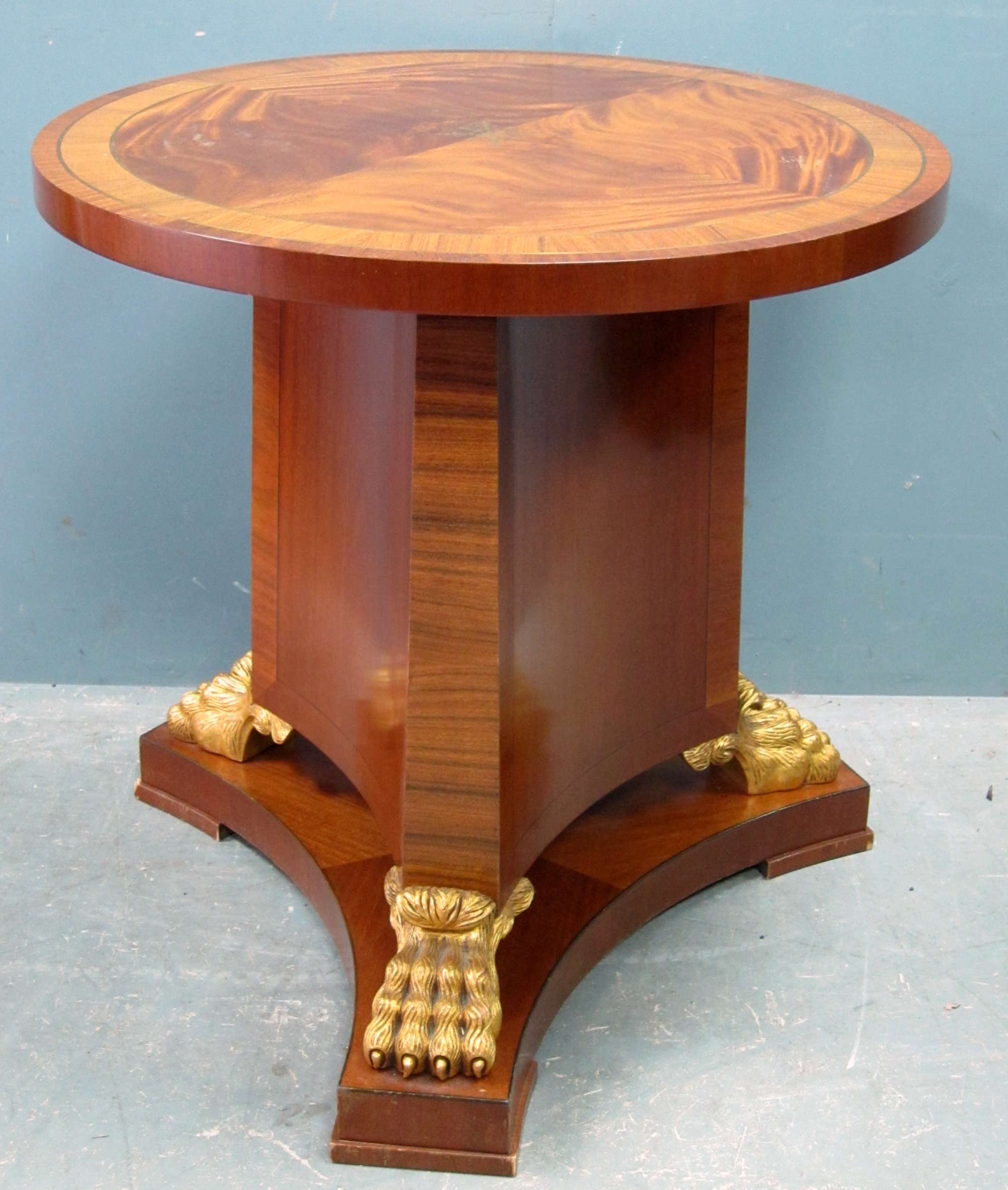 Appraisal: Reproduction circular mahogany table on shaped column gilt lion's paw