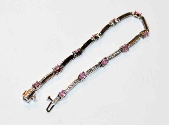 Appraisal: A CONTEMPORARY DIAMOND AND PINK TOURMALINE BRACELET eleven oval claw