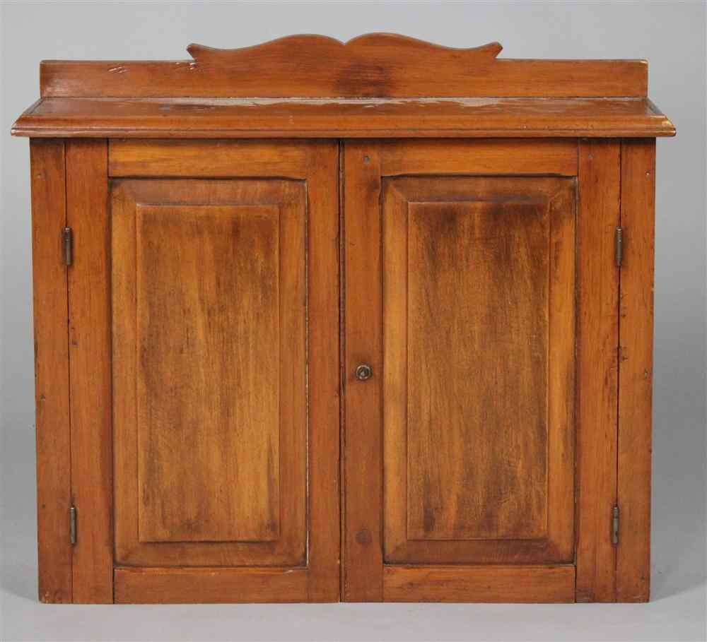 Appraisal: AMERICAN PINE HANGING WALL CUPBOARD having a shaped crest over